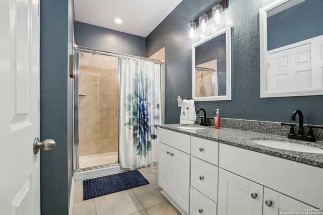 a bathroom with sinks granite and a mirror