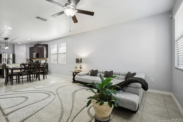a living room with furniture flowerpot and a chandelier