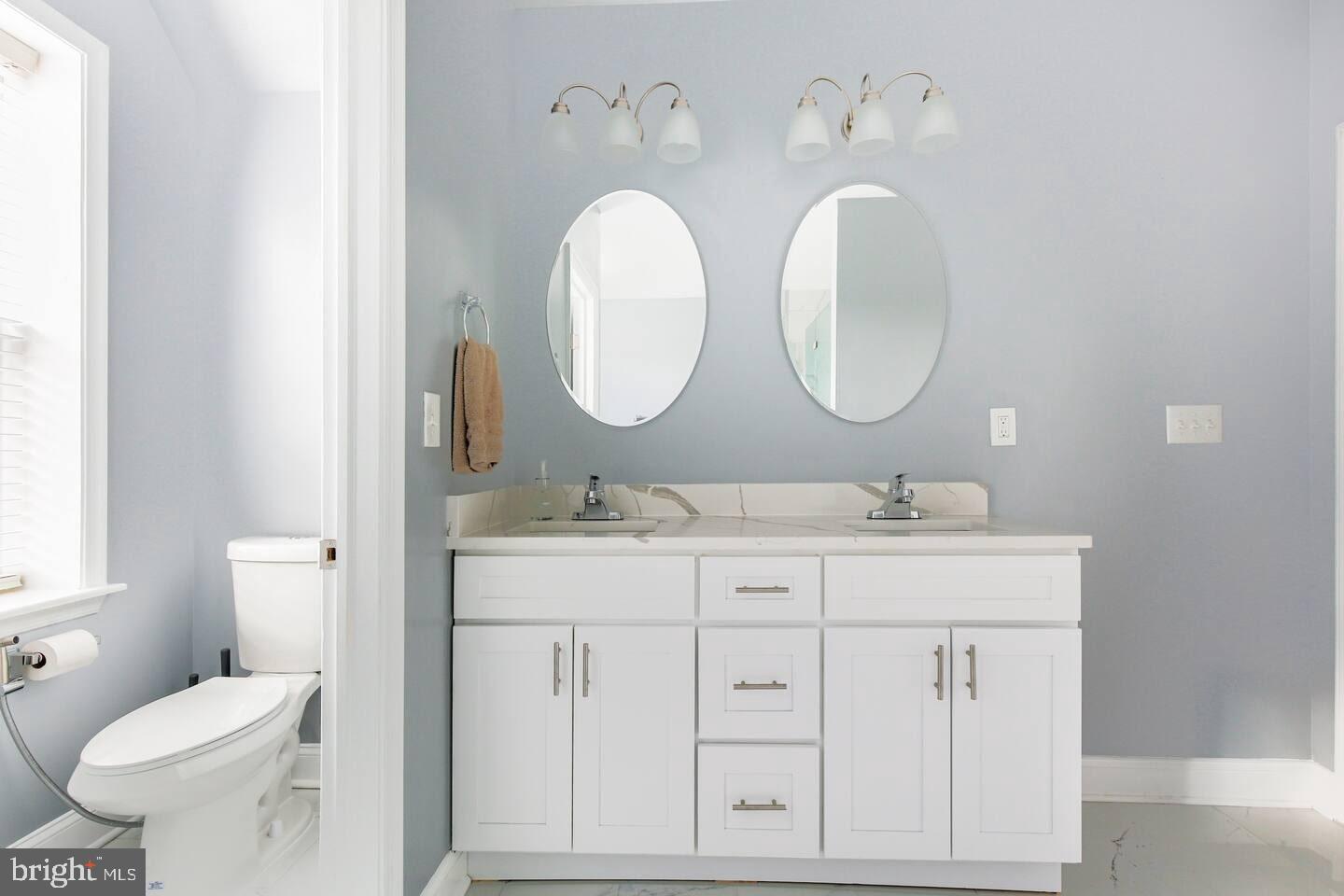 5 East 27th Street Baltimore, MD 21218 - Photo 14 of 34 a bathroom with a double vanity sink and a mirror
