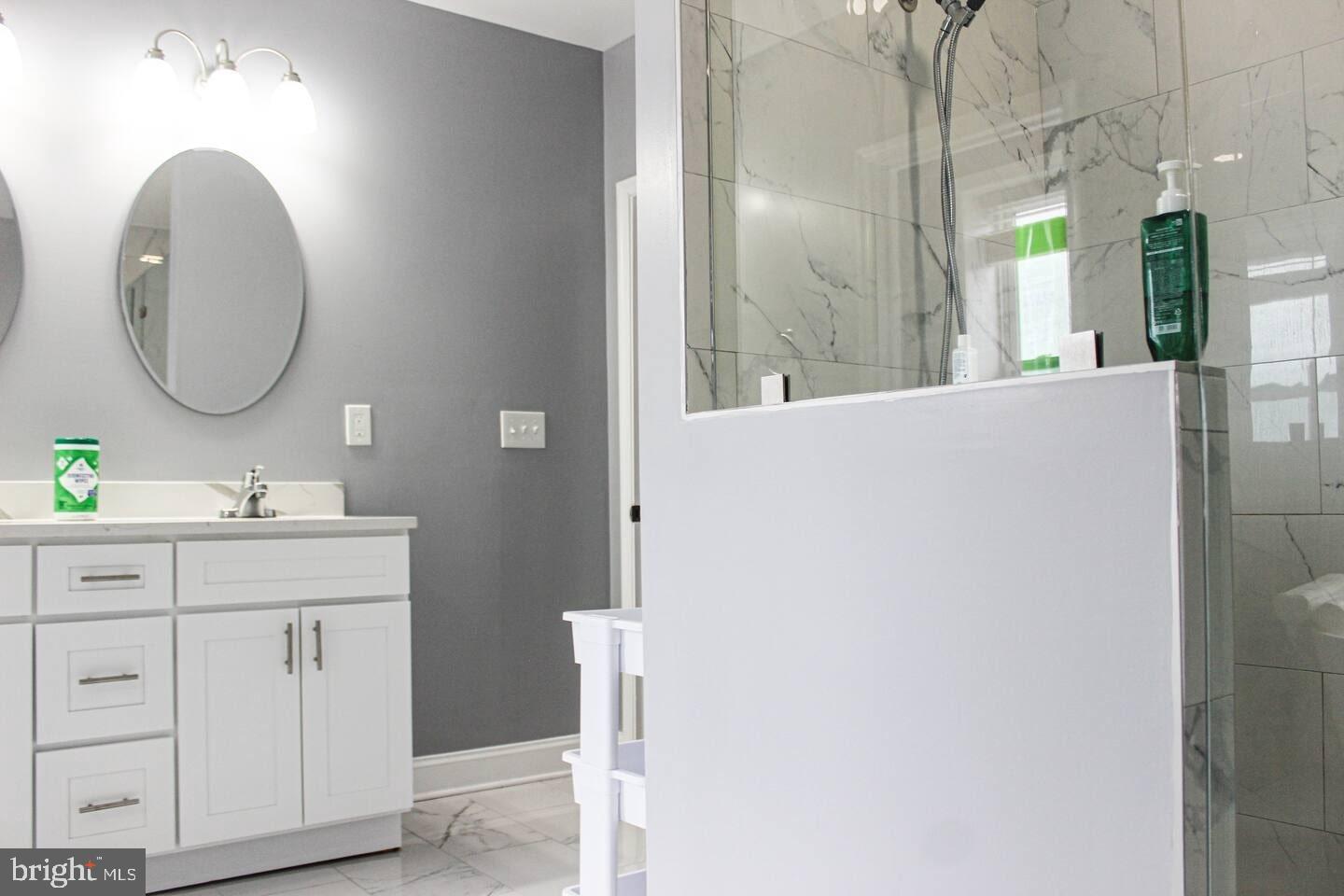 5 East 27th Street Baltimore, MD 21218 - Photo 18 of 34 a bathroom with a double vanity sink and a mirror