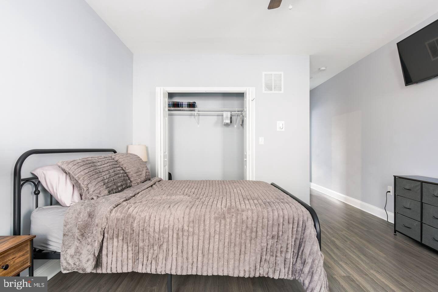 5 East 27th Street Baltimore, MD 21218 - Photo 19 of 34 a bedroom with a bed and wooden floor