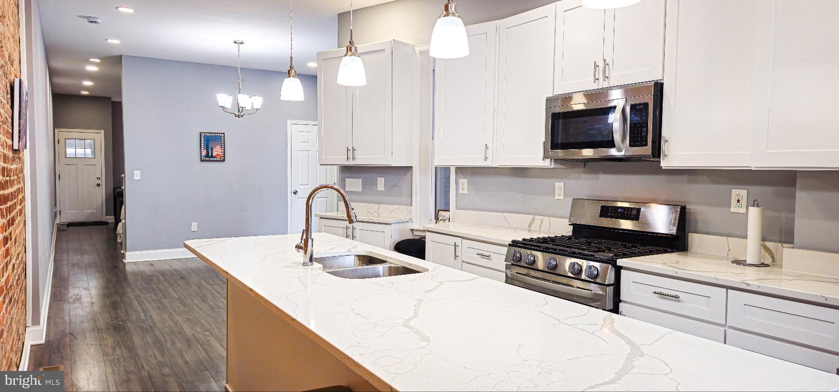 5 East 27th Street Baltimore, MD 21218 - Photo 2 of 34 a kitchen with stainless steel appliances a sink a stove top oven a counter space and cabinets