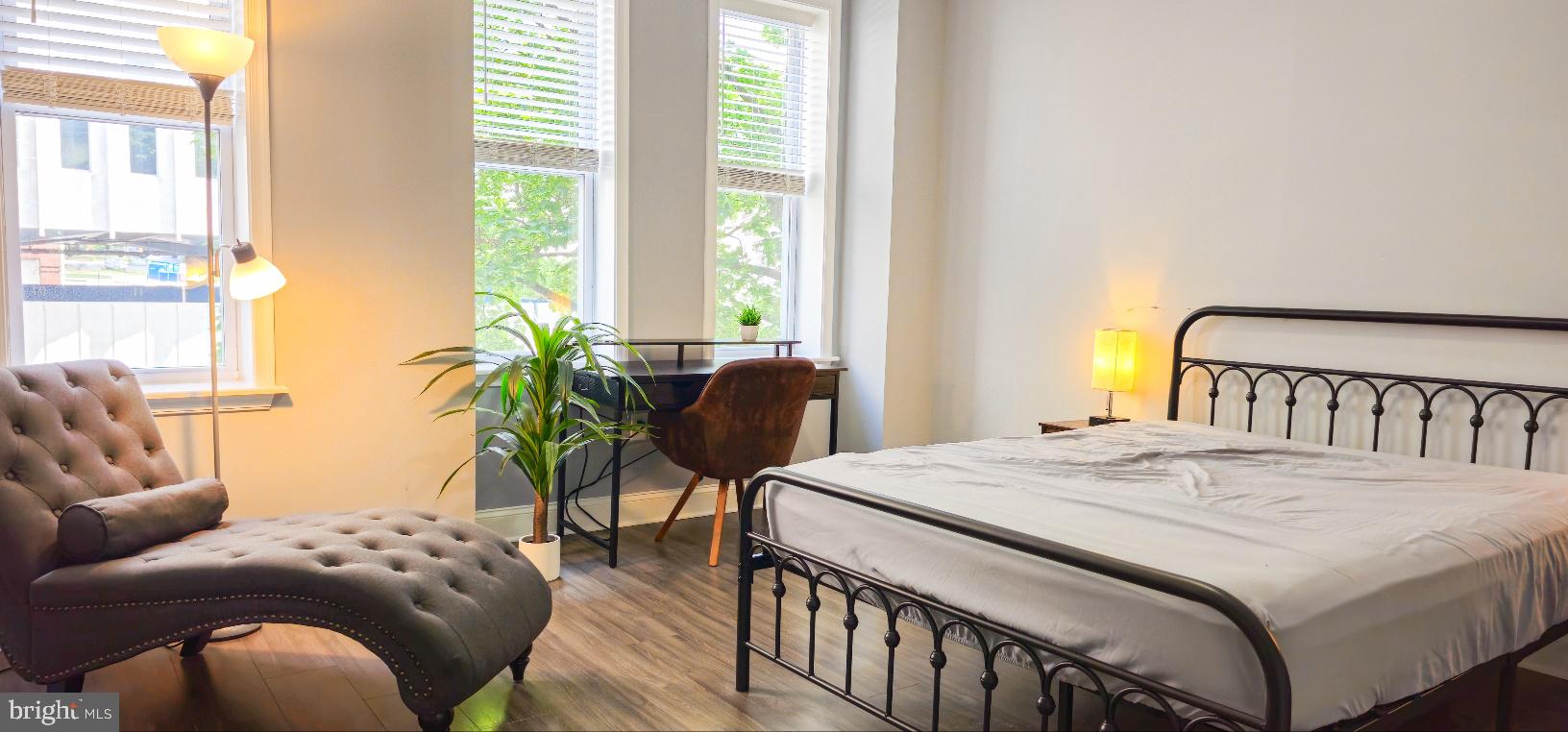 5 East 27th Street Baltimore, MD 21218 - Photo 21 of 34 a bedroom with a bed a couch and a potted plant