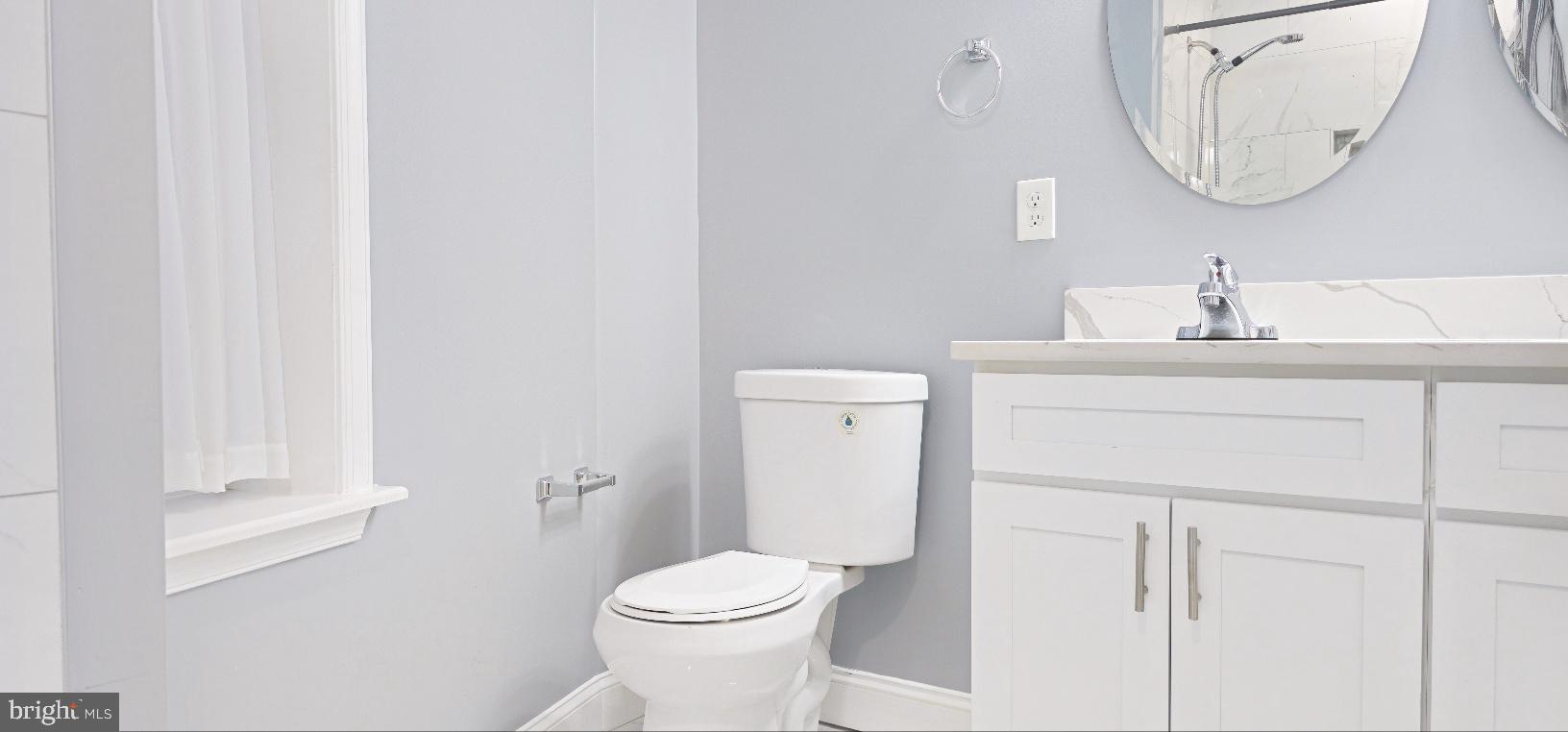 5 East 27th Street Baltimore, MD 21218 - Photo 25 of 34 a bathroom with a toilet a sink a vanity and mirror