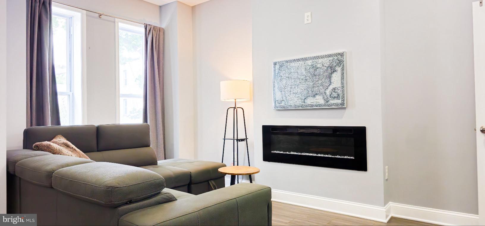 5 East 27th Street Baltimore, MD 21218 - Photo 4 of 34 a living room with furniture a window and a fireplace