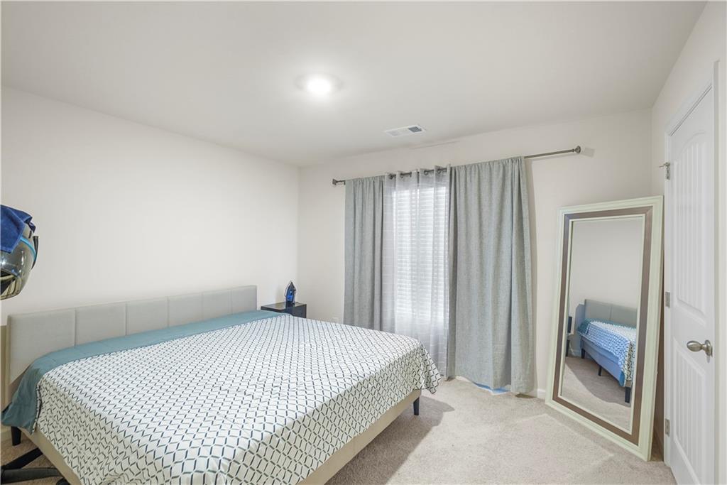 499 Walnut Grv Way Pendergrass, GA 30567 - Photo 16 of 19 a bedroom with a bed and a mirror
