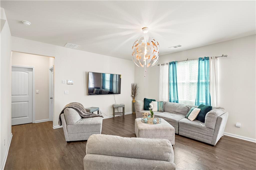 499 Walnut Grv Way Pendergrass, GA 30567 - Photo 4 of 19 a living room with furniture and a chandelier