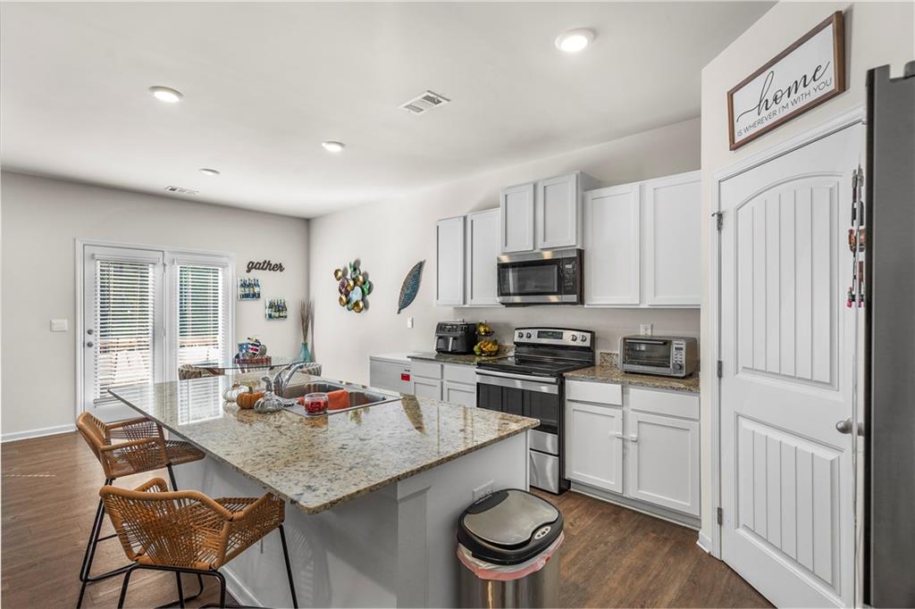499 Walnut Grv Way Pendergrass, GA 30567 - Photo 6 of 19 a kitchen with stainless steel appliances kitchen island granite countertop a sink and cabinets