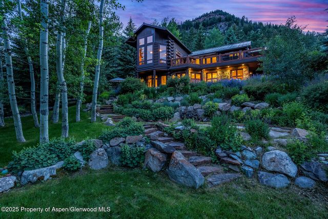 a view of a big house with a big yard and large trees