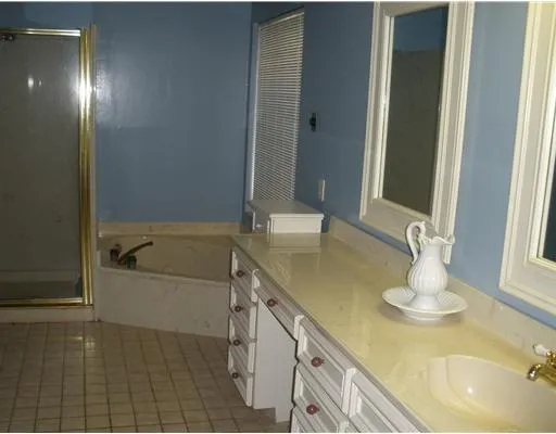 a bathroom with a tub sink and mirror