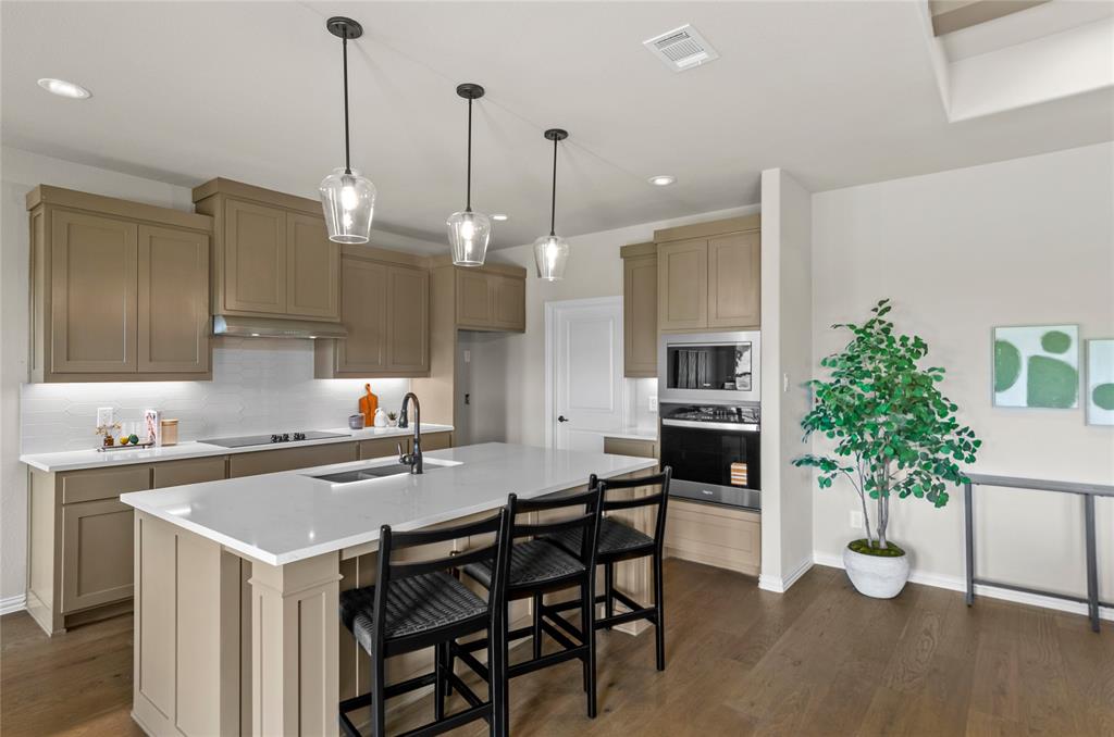 205 Stuart Paradise, TX 76073 - Photo 14 of 33 a kitchen with a table a sink and cabinets