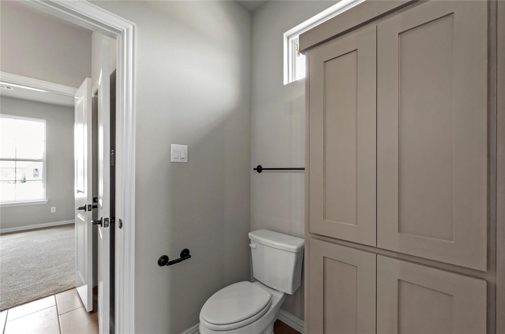 205 Stuart Paradise, TX 76073 - Photo 21 of 33 a white toilet sitting next to a bathroom sink