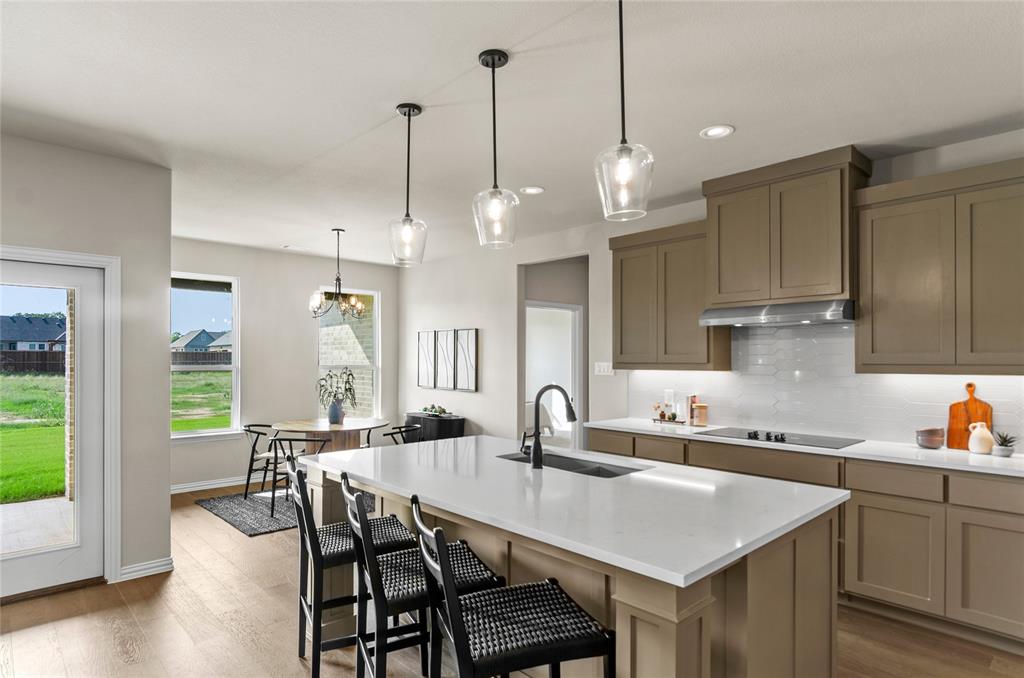 205 Stuart Paradise, TX 76073 - Photo 10 of 33 a kitchen with stainless steel appliances granite countertop a sink a stove a dining table and chairs