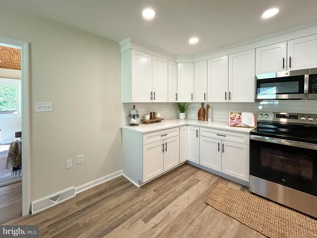 a kitchen with granite countertop white cabinets and white appliances