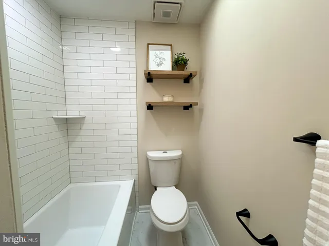 a white toilet sitting in a bathroom next to a sink