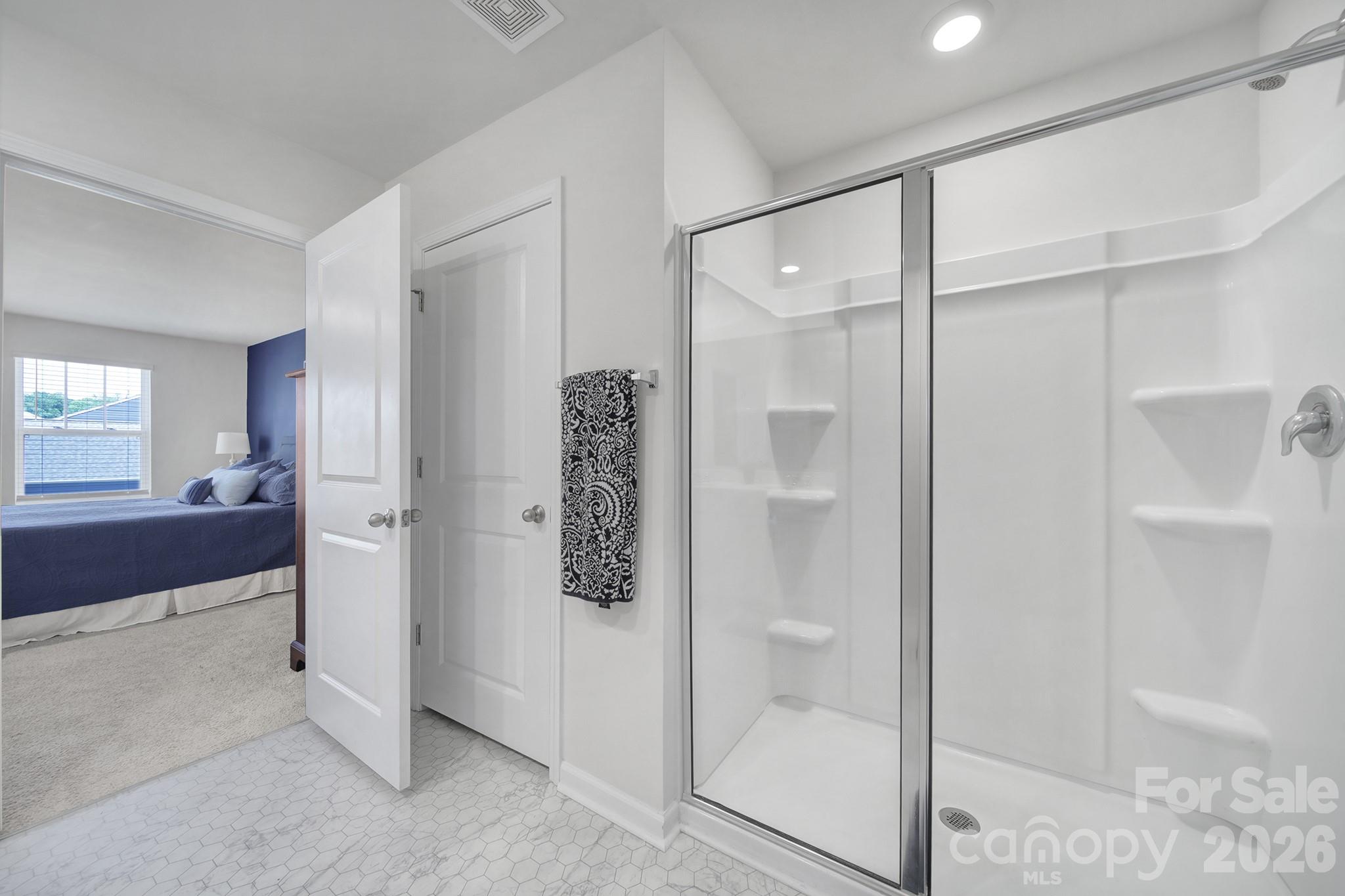 107 Spring Hall Court Troutman, NC 28166 - Photo 16 of 28 a bathroom with a shower and a glass door