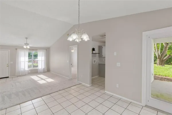 a view of a livingroom with a chandelier fan and windows