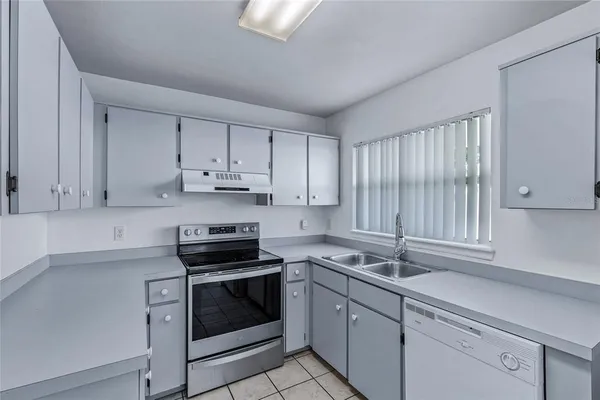 a kitchen with granite countertop white cabinets white appliances and a sink