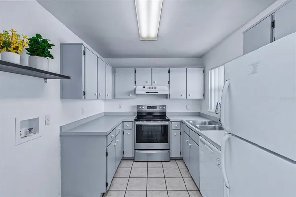 a kitchen with a stove sink and cabinets