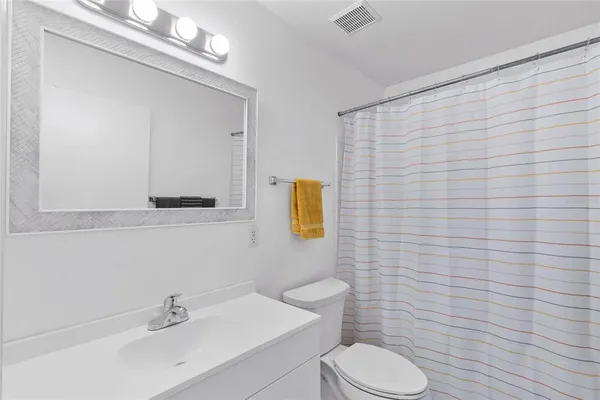 a bathroom with a sink a toilet and mirror