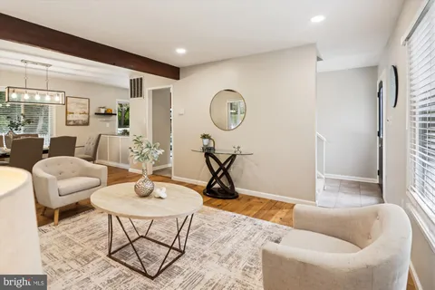 a dining room with wooden floor a chandelier a wooden table and chairs