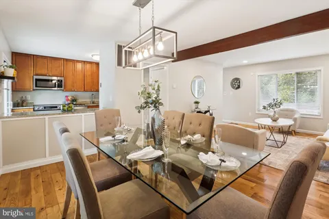 a dining room with furniture a chandelier and wooden floor