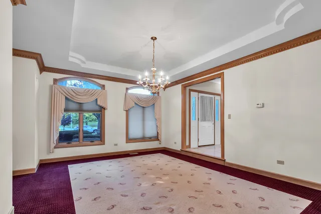 an empty room with windows and a ceiling fan