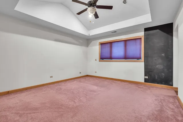a view of an empty room with wooden floor and a fireplace