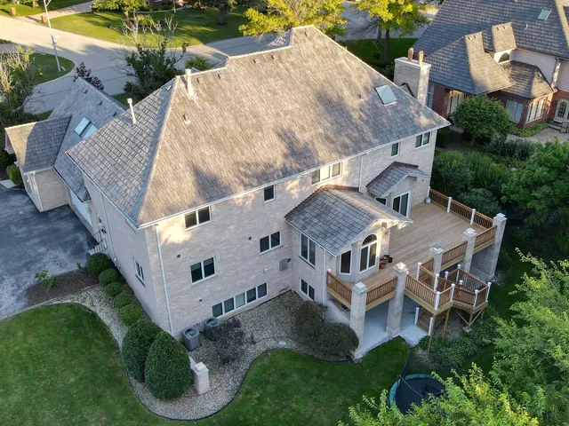 an aerial view of a house with a yard and lake view