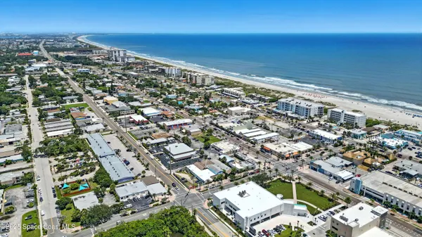 an aerial view of residential houses with outdoor space and ocean view