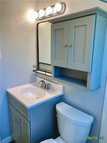 a bathroom with a toilet sink and mirror