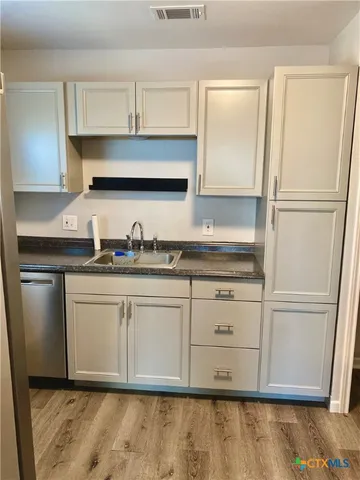 a kitchen with granite countertop white cabinets and white appliances