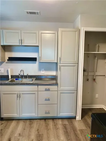 a kitchen with granite countertop a refrigerator and a sink