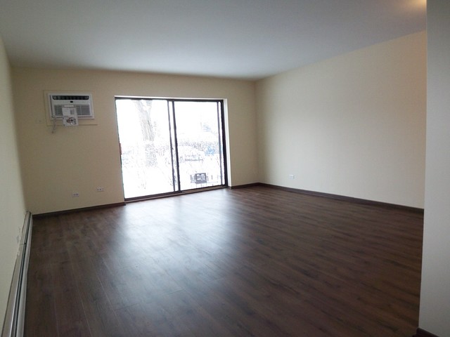 235 North Mill Road, Unit 106B Addison, IL 60101 - Photo 13 of 24 a view of an empty room with wooden floor and a window