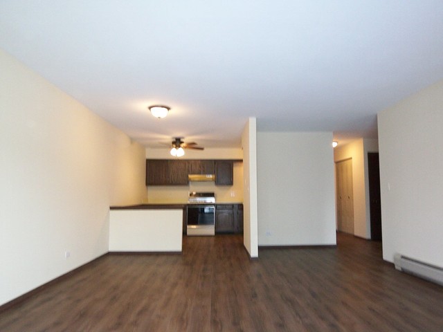 235 North Mill Road, Unit 106B Addison, IL 60101 - Photo 15 of 24 a view of a kitchen with wooden floor and electronic appliances
