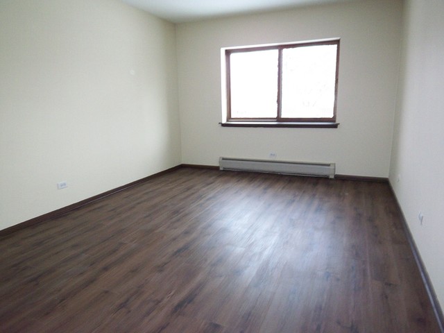 235 North Mill Road, Unit 106B Addison, IL 60101 - Photo 16 of 24 an empty room with wooden floor and windows