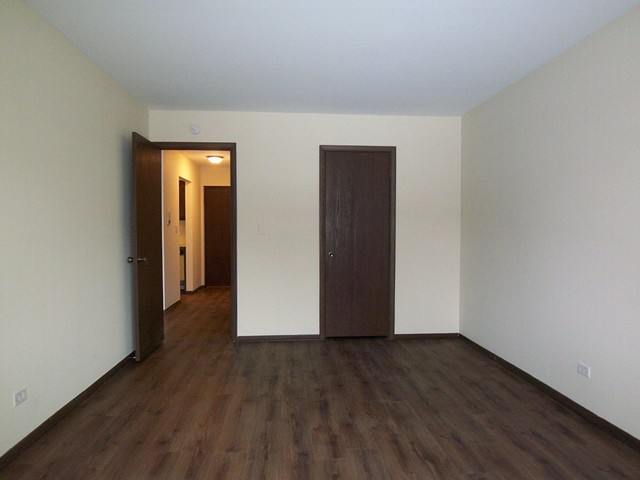 235 North Mill Road, Unit 106B Addison, IL 60101 - Photo 17 of 24 a view of an empty room with wooden floor and closet
