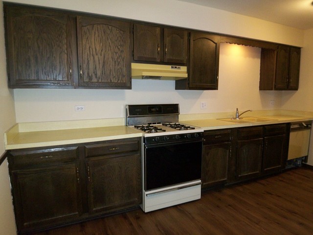 235 North Mill Road, Unit 106B Addison, IL 60101 - Photo 5 of 24 a kitchen with granite countertop wood cabinets and a stove