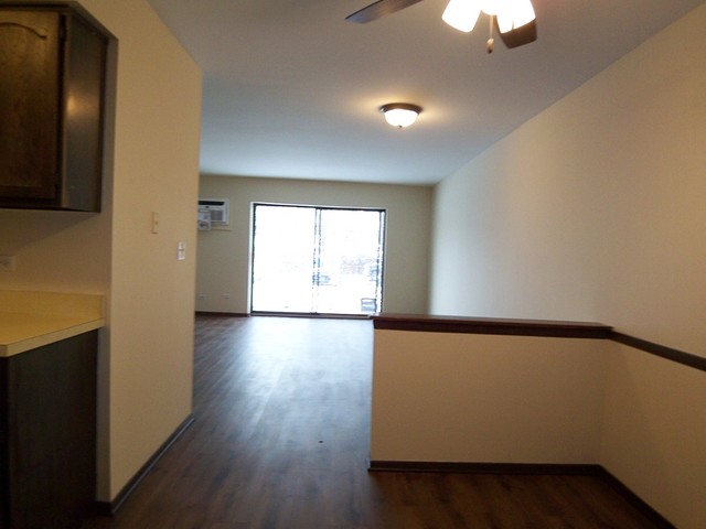 235 North Mill Road, Unit 106B Addison, IL 60101 - Photo 9 of 24 a view of an empty room with wooden floor and a window