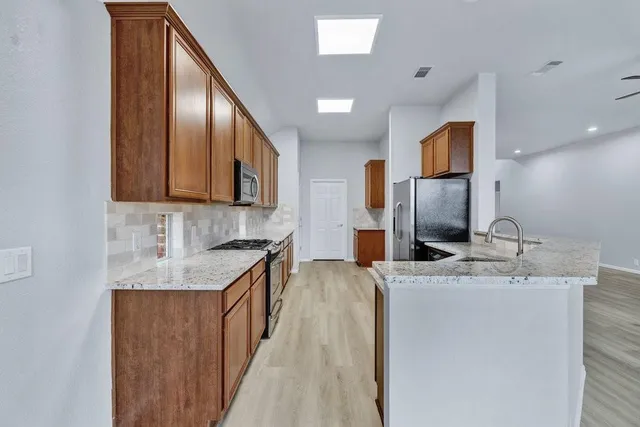 a kitchen with stainless steel appliances granite countertop a sink stove and refrigerator