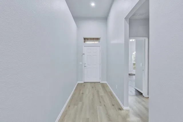a view of a room with wooden floor and mirror