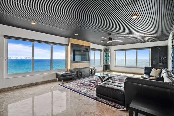 a living room with furniture and large windows