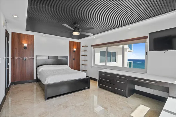 a bedroom with a large bed and a tv on dresser
