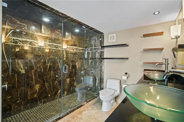a bathroom with a sink toilet and shower