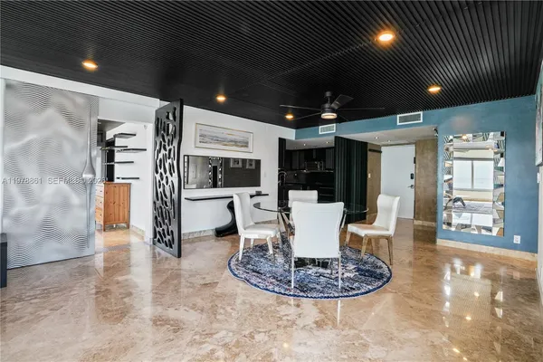 a dining room with kitchen island stainless steel appliances furniture a fireplace and a chandelier