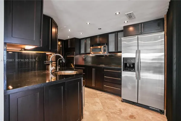 a kitchen with kitchen island a counter top space cabinets and stainless steel appliances