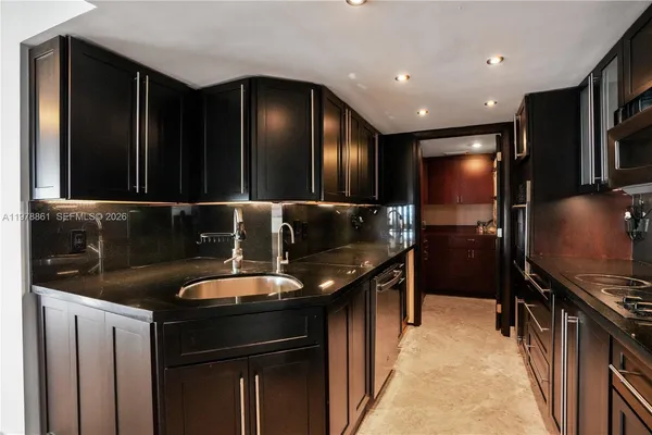 a kitchen with stainless steel appliances granite countertop a sink and a refrigerator
