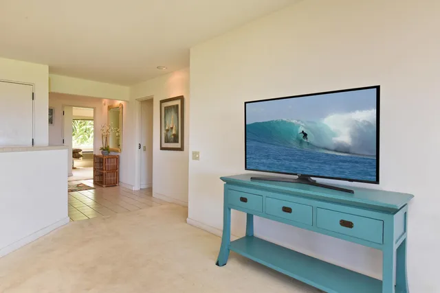 a room with painting on the wall and a dresser