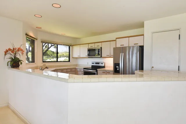 a view of a kitchen with a sink a window and stainless steel appliances