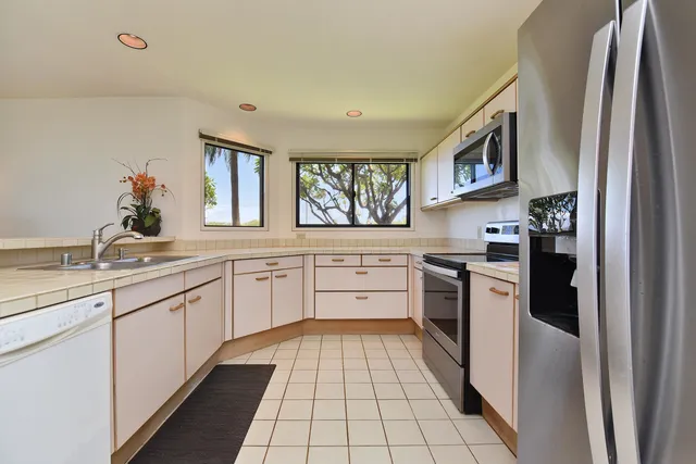 a kitchen with stainless steel appliances granite countertop a refrigerator and a sink